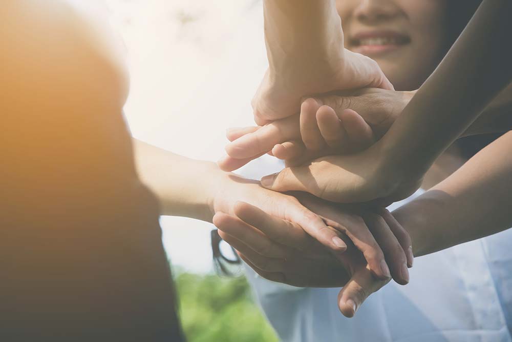 Kinder legen ihre Hände übereinander